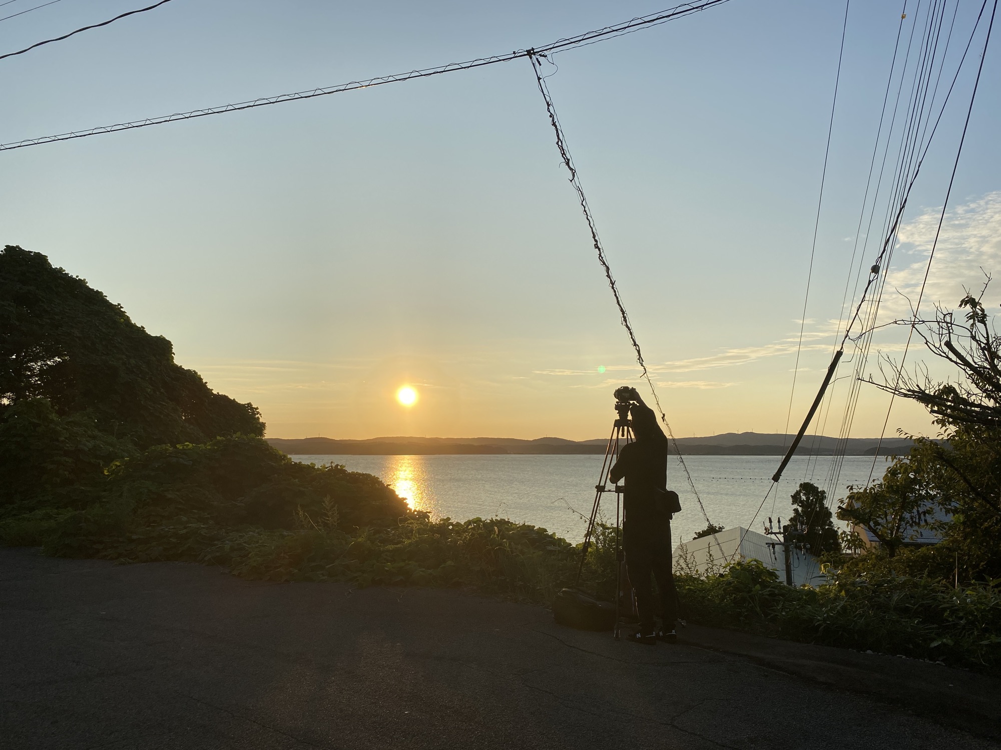 七尾湾に沈む夕日を撮影する様子